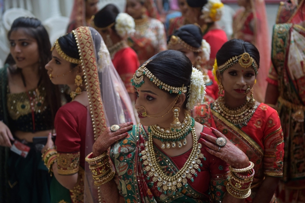 Hindu brides gather as they wait to participate in a mass marriage ceremony at Surat in India's Gujarat state on December 4, 2021. (Photo by Sam PANTHAKY / AFP)