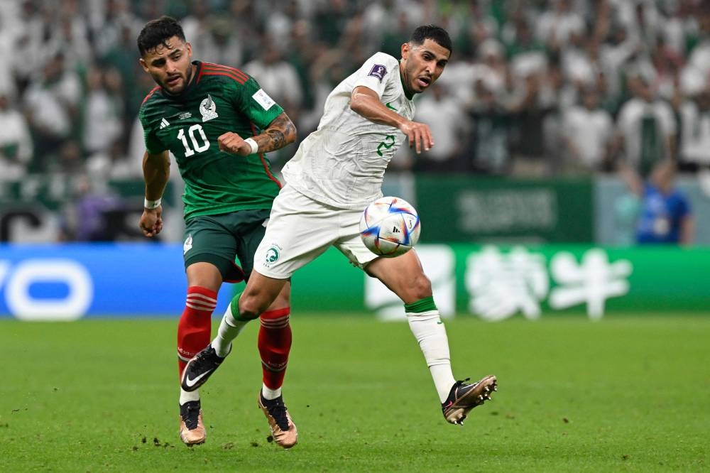 Mexico's forward #10 Alexis Vega (L) fights for the ball with Saudi Arabia's defender #02 Sultan Al-Ghanam (R) during the Qatar 2022 World Cup Group C football match between Saudi Arabia and Mexico at the Lusail Stadium in Lusail, north of Doha on November 30, 2022. (Photo by Alfredo ESTRELLA / AFP)