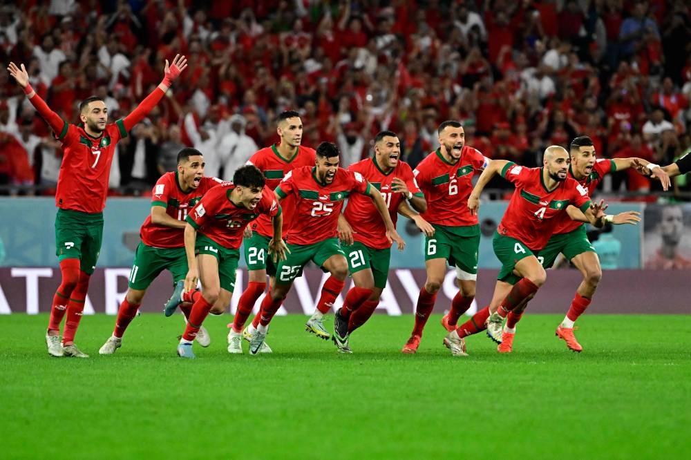 TOPSHOT - Morocco's celebrate winning during the penalty shoot-out to win the Qatar 2022 World Cup round of 16 football match between Morocco and Spain at the Education City Stadium in Al-Rayyan, west of Doha on December 6, 2022. (Photo by JAVIER SORIANO / AFP)